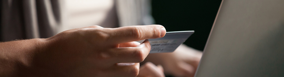 Person using a debit card on a laptop