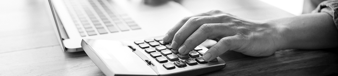 Man using a laptop and calculator