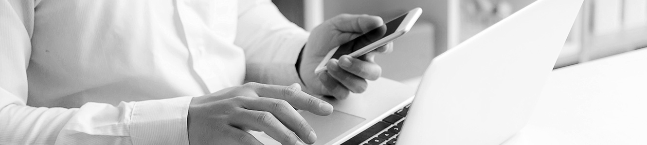 Man using a smartphone and a laptop